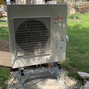 Fujitsu DC Inverter hőszivattyú kültéri egysége horganyzott állványon, kerti környezetben